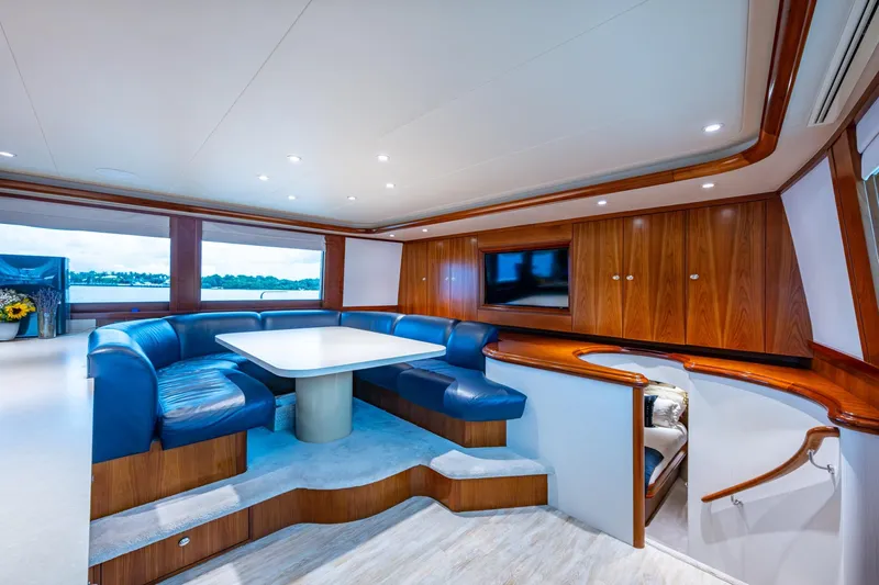 Lila Cuy Yacht Photos Pics Luxurious interior of 2006 Westport 112 yacht with blue seating and wooden cabinetry.