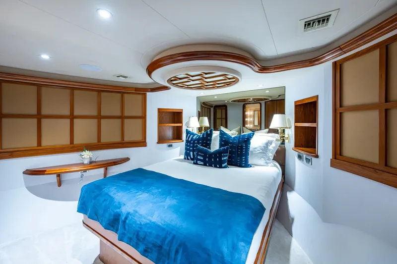 Lila Cuy Yacht Photos Pics Luxurious 2006 Westport 112 yacht bedroom with elegant wood accents and blue bedding.