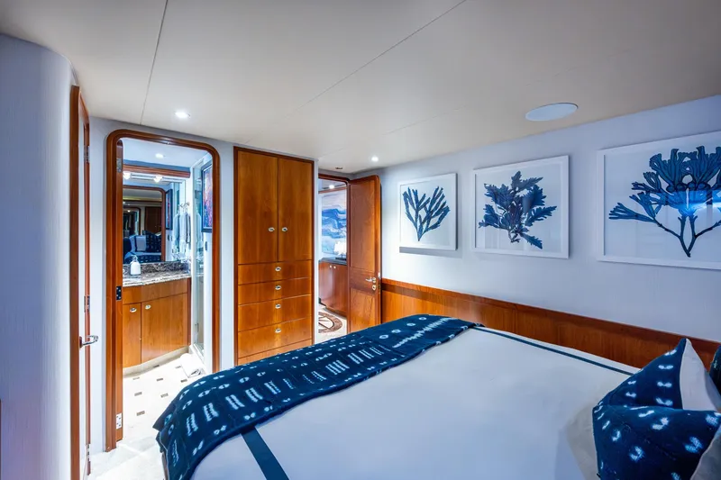 Lila Cuy Yacht Photos Pics Luxurious bedroom interior on 2006 Westport 112 yacht, featuring elegant wood finishes and marine-themed artwork.