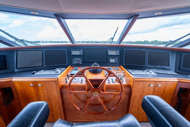 Lila Cuy Yacht Photos Pics Helm of 2006 Westport 112 yacht with wooden steering wheel and multiple navigation screens.