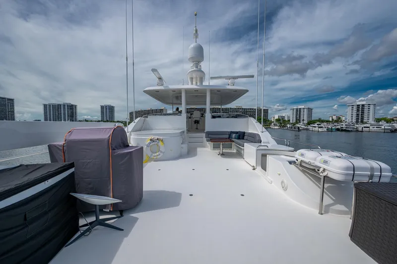 Lila Cuy Yacht Photos Pics Luxurious 2006 Westport 112 yacht deck with seating, overlooking waterfront cityscape.