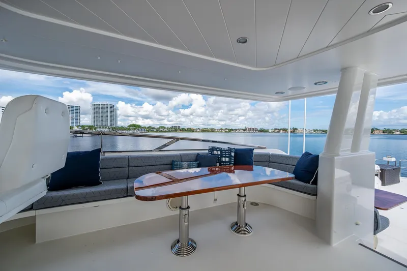 Lila Cuy Yacht Photos Pics Luxurious 2006 Westport 112 yacht deck with seating, table, and scenic waterfront view.