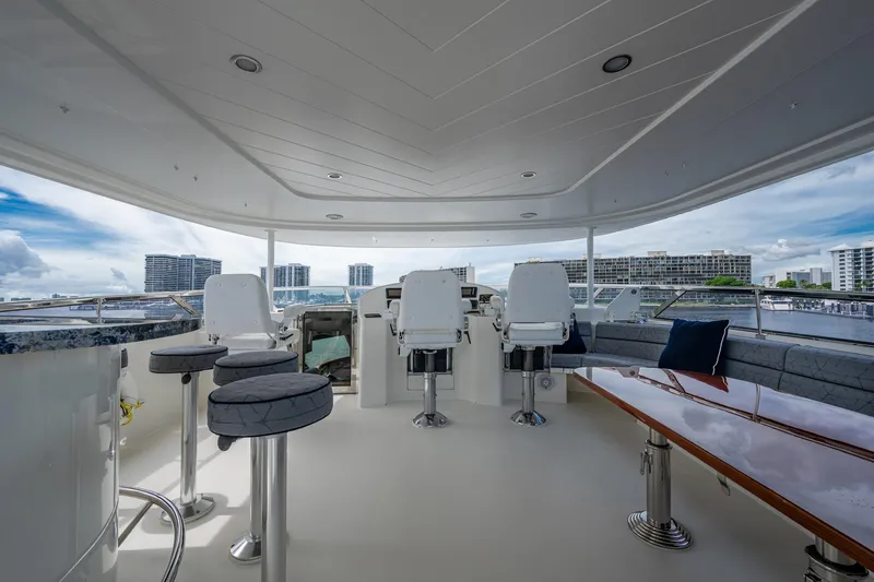 Lila Cuy Yacht Photos Pics Luxurious 2006 Westport 112 yacht deck with seating, bar stools, and cityscape view.