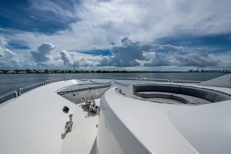 Lila Cuy Yacht Photos Pics Luxurious 2006 Westport 112 yacht deck with seating, under a dramatic cloudy sky.
