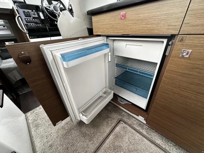  Yacht Photos Pics Open fridge in 2019 Jeanneau Merry Fisher 1095 FLY boat interior, showcasing modern design.