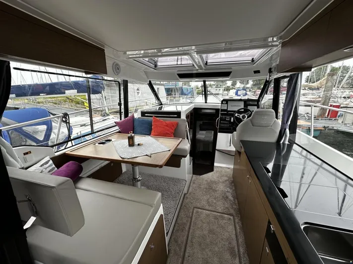  Yacht Photos Pics Interior of 2019 Jeanneau Merry Fisher 1095 FLY boat with seating and helm.