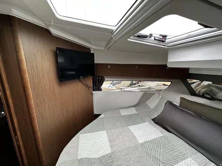  Yacht Photos Pics Interior of 2019 Jeanneau Merry Fisher 1095 FLY with cozy bed and wall-mounted TV.