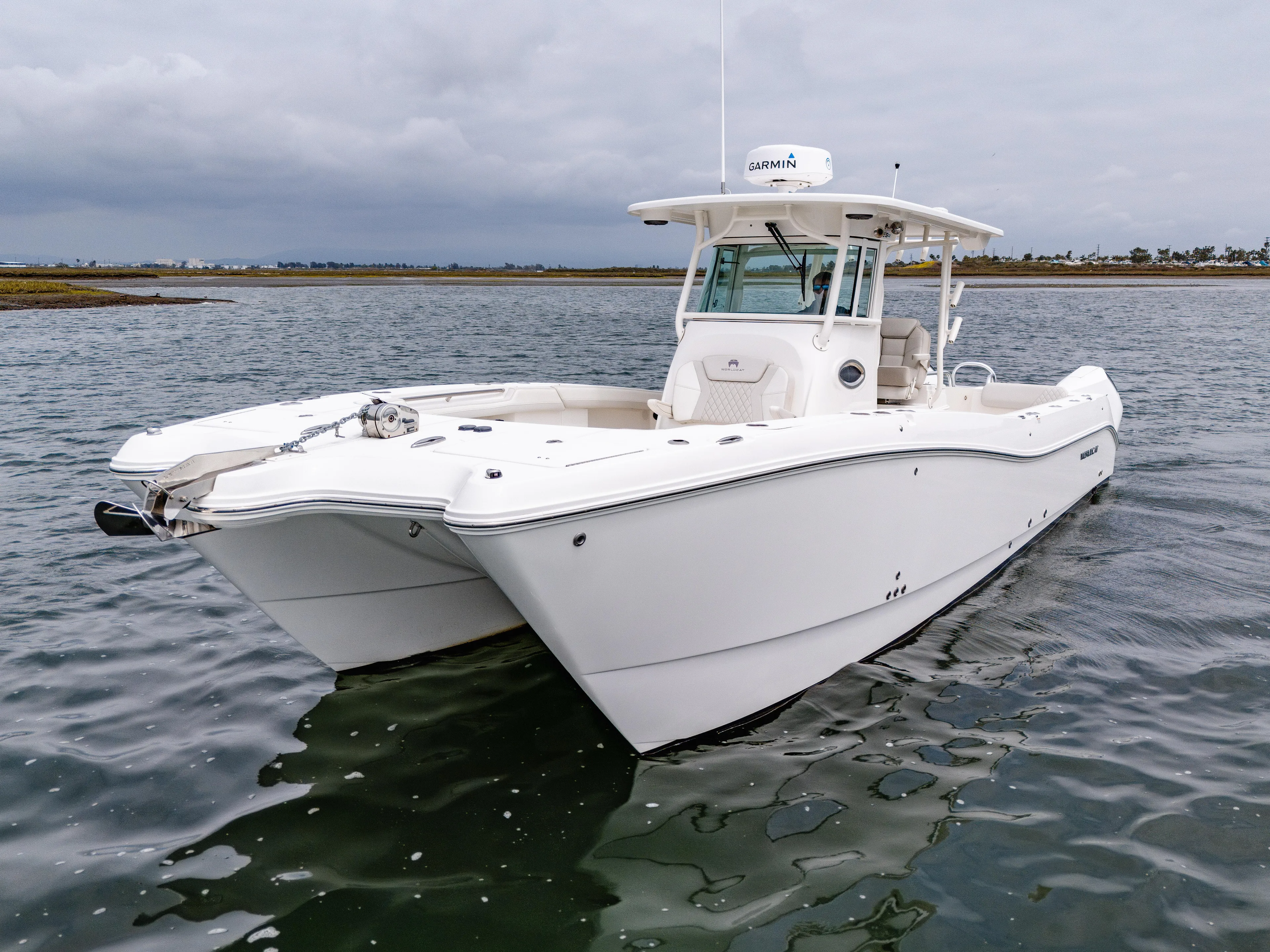  Yacht Photos Pics 2024 World Cat 325 CC boat on calm water, showcasing sleek design and modern features.