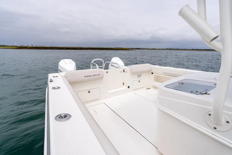  Yacht Photos Pics 2024 World Cat 325 CC boat on calm water, showcasing spacious deck and seating.