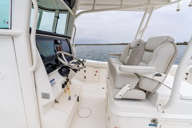  Yacht Photos Pics 2024 World Cat 325 CC boat interior with helm and seating, on calm water.