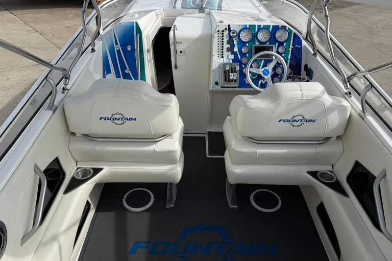  Yacht Photos Pics 2010 Fountain 42 Lightning boat interior with white seats and blue dashboard.