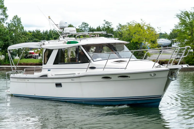  Yacht Photos Pics 2020 Cutwater C28 boat cruising on a calm waterway, surrounded by lush greenery.