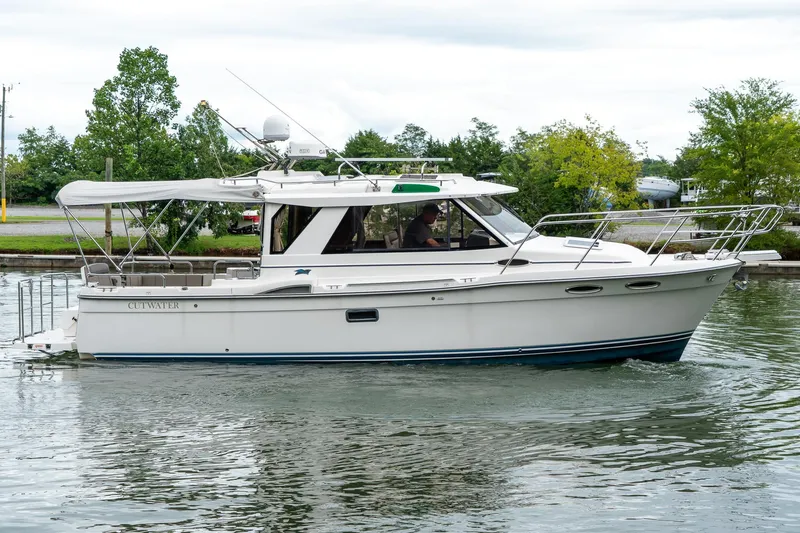  Yacht Photos Pics 2020 Cutwater C28 boat cruising on a calm waterway, surrounded by greenery.