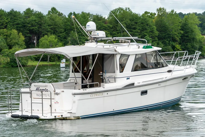  Yacht Photos Pics 2020 Cutwater C28 boat cruising on a serene lake with lush green trees.