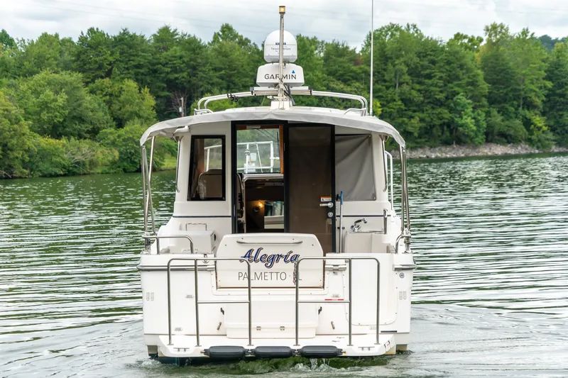  Yacht Photos Pics 2020 Cutwater C28 boat on a serene lake with lush green forest backdrop.