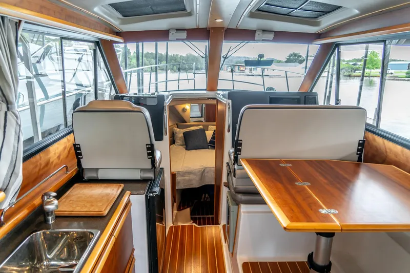 Yacht Photos Pics 2020 Cutwater C28 interior with wood accents, dining area, and cozy cabin.