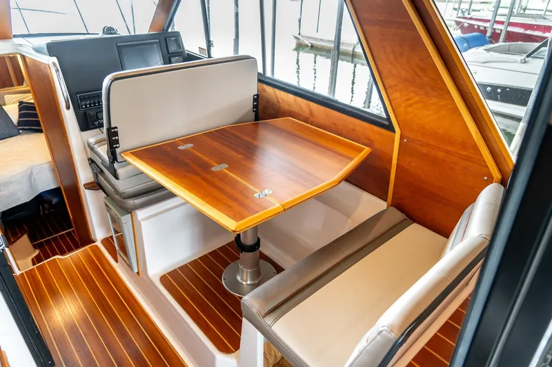 Yacht Photos Pics 2020 Cutwater C28 boat interior with wooden table and seating area.