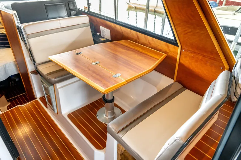  Yacht Photos Pics 2020 Cutwater C28 interior with wooden table and cushioned seating.