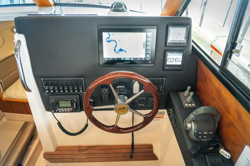 Yacht Photos Pics 2020 Cutwater C28 helm with navigation display, controls, and wooden steering wheel.