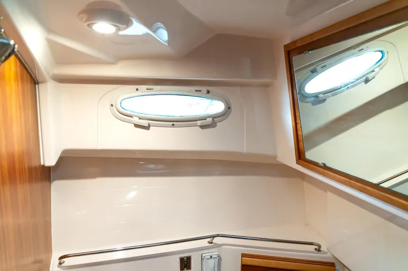  Yacht Photos Pics 2020 Cutwater C28 boat interior with porthole and mirror in bathroom.