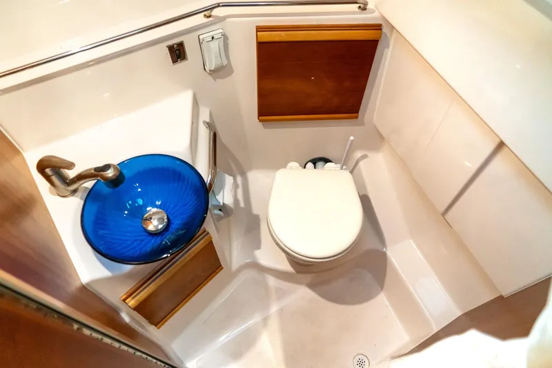  Yacht Photos Pics 2020 Cutwater C28 boat bathroom with blue glass sink and compact toilet.