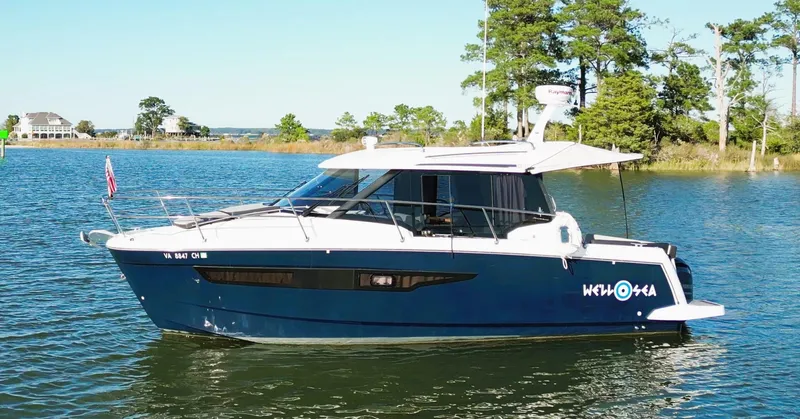  Yacht Photos Pics 2021 Jeanneau NC 895 boat on a serene lake with trees in the background.