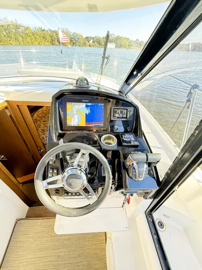  Yacht Photos Pics 2021 Jeanneau NC 895 helm with navigation system on a calm lake.