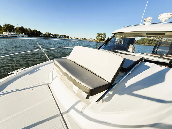  Yacht Photos Pics 2021 Jeanneau NC 895 boat with sun deck seating on calm water.