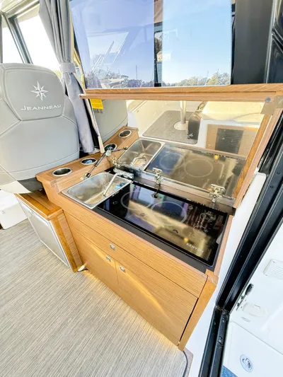  Yacht Photos Pics 2021 Jeanneau NC 895 boat interior with kitchenette and seating area.