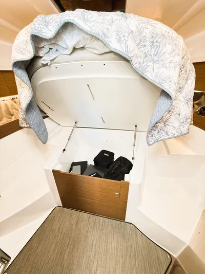  Yacht Photos Pics 2021 Jeanneau NC 895 interior storage compartment with open lid and items inside.