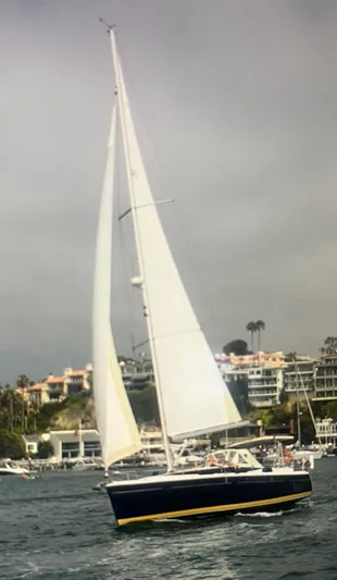 Pegasus Yacht Photos Pics 2015 Marlow-Hunter 40 sailboat cruising near coastal buildings under cloudy skies.