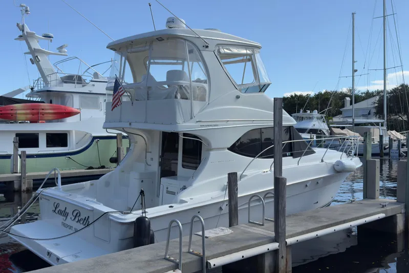  Yacht Photos Pics 2004 Silverton 38 Convertible yacht docked at marina with American flag.