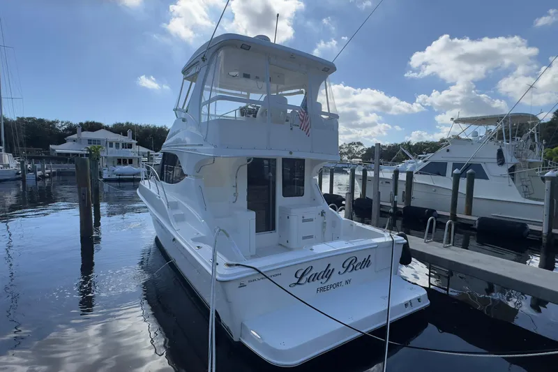  Yacht Photos Pics 2004 Silverton 38 Convertible yacht docked at marina under blue sky.