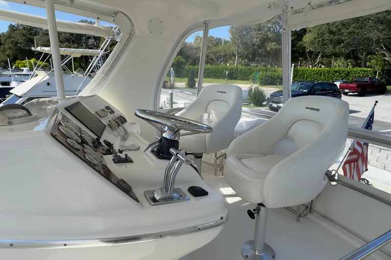  Yacht Photos Pics 2004 Silverton 38 Convertible yacht helm with white captain chairs and control panel.