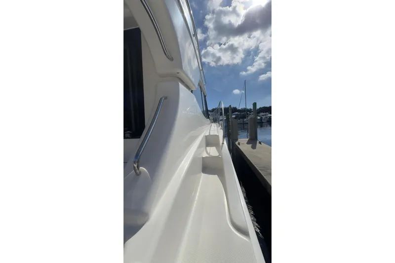  Yacht Photos Pics 2004 Silverton 38 Convertible yacht docked under a partly cloudy sky.