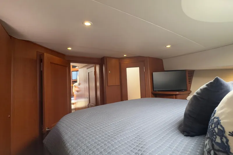  Yacht Photos Pics Luxurious cabin interior of 2004 Silverton 38 Convertible yacht with cozy bedding and TV.