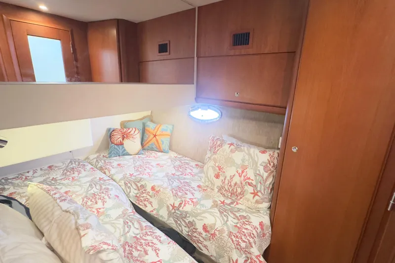  Yacht Photos Pics Cozy cabin interior of 2004 Silverton 38 Convertible with floral bedding and wooden accents.