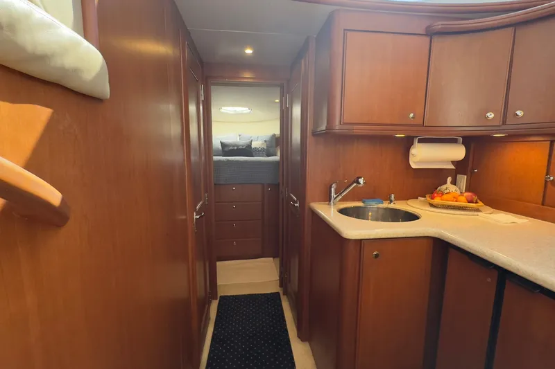  Yacht Photos Pics 2004 Silverton 38 Convertible yacht interior with wood cabinetry and compact kitchen area.