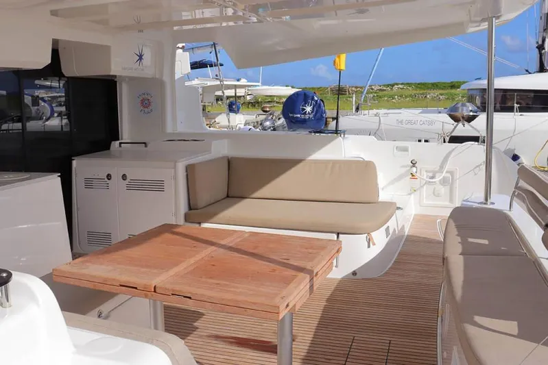  Yacht Photos Pics 2023 Lagoon 46 yacht interior with cushioned seating and wooden table.