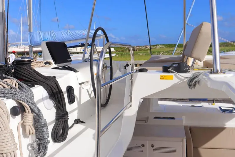  Yacht Photos Pics 2023 Lagoon 46 yacht cockpit with ropes, steering wheel, and navigation equipment.