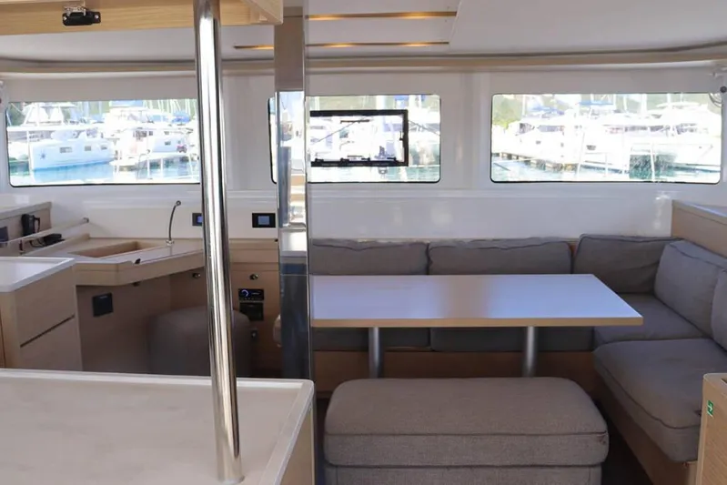  Yacht Photos Pics Interior of 2023 Lagoon 46 catamaran with modern seating and large windows.