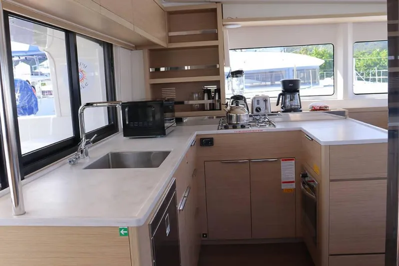  Yacht Photos Pics Modern kitchen interior of 2023 Lagoon 46 yacht with appliances and sleek design.