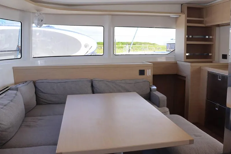  Yacht Photos Pics Modern interior of 2023 Lagoon 46 yacht with cozy seating and wooden table.