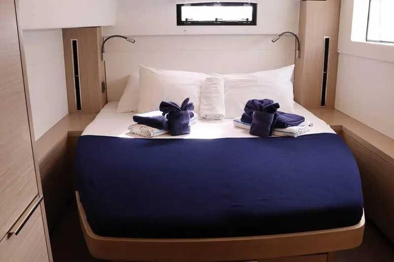  Yacht Photos Pics Luxurious cabin interior of 2023 Lagoon 46 yacht with neatly arranged bed and towels.