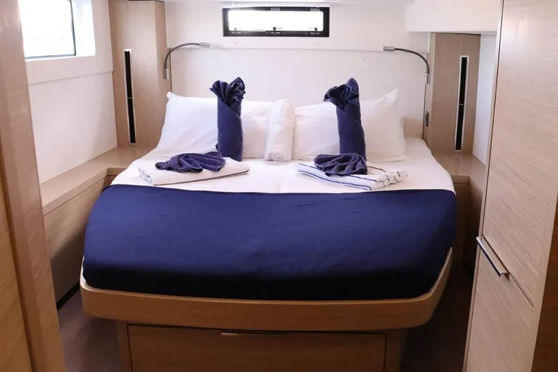  Yacht Photos Pics Luxurious cabin interior of 2023 Lagoon 46 yacht with neatly arranged bed and towels.