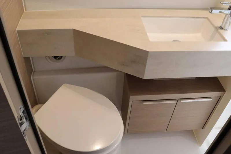 Yacht Photos Pics Modern bathroom in 2023 Lagoon 46 yacht with sink, toilet, and storage cabinet.