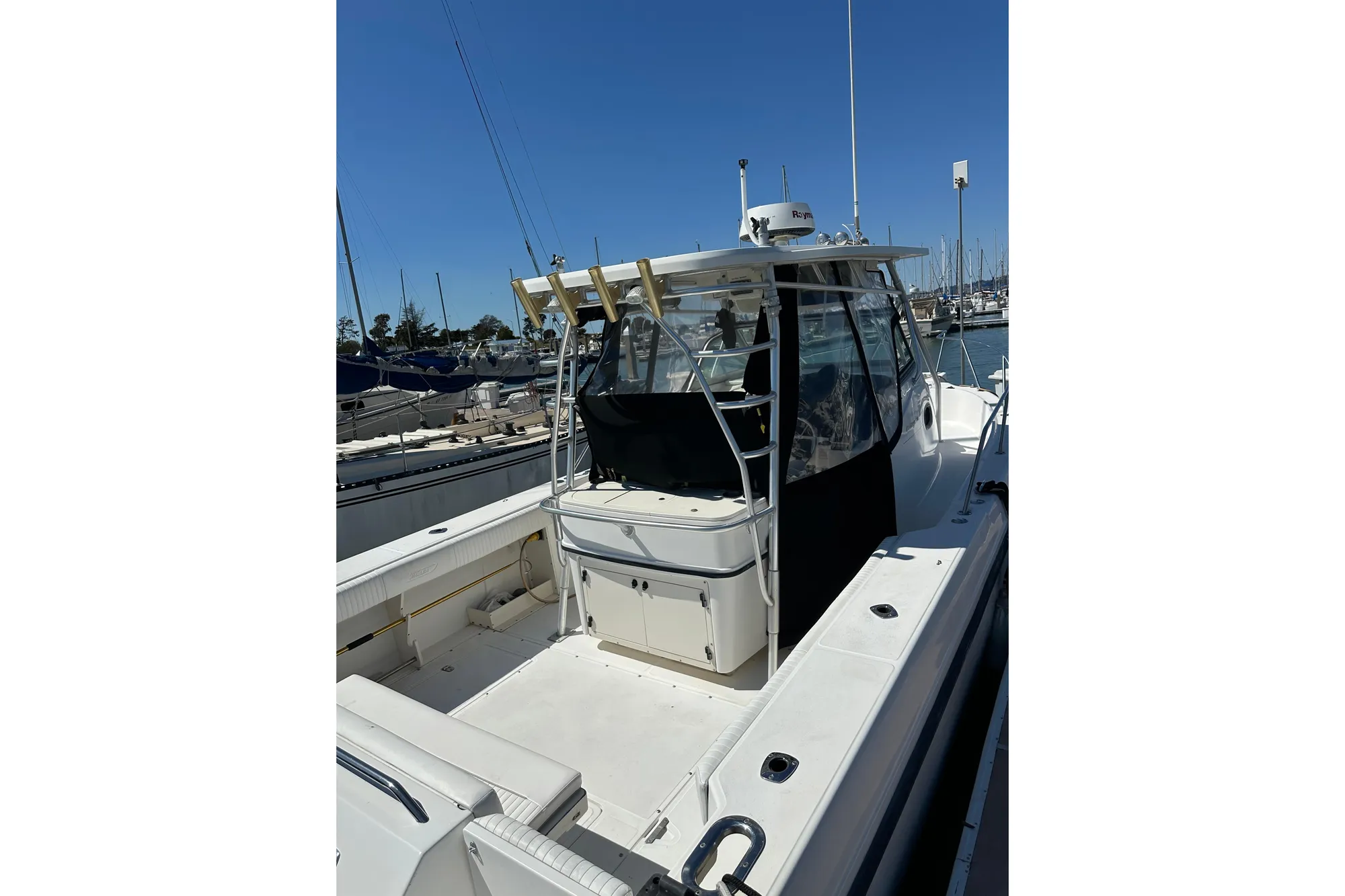2001 Boston Whaler 28 Outrage boat docked at marina under clear blue sky.