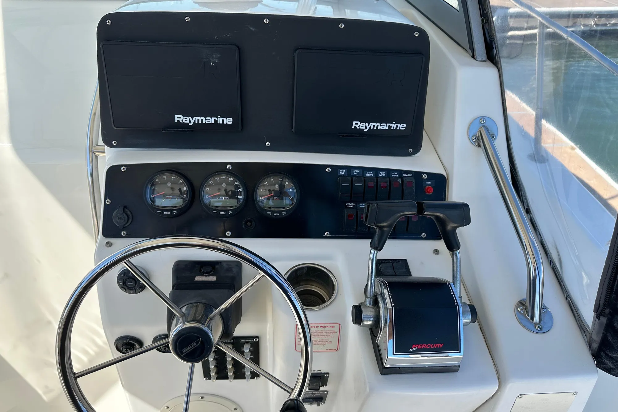 Helm of 2001 Boston Whaler 28 Outrage with Raymarine electronics and Mercury controls.