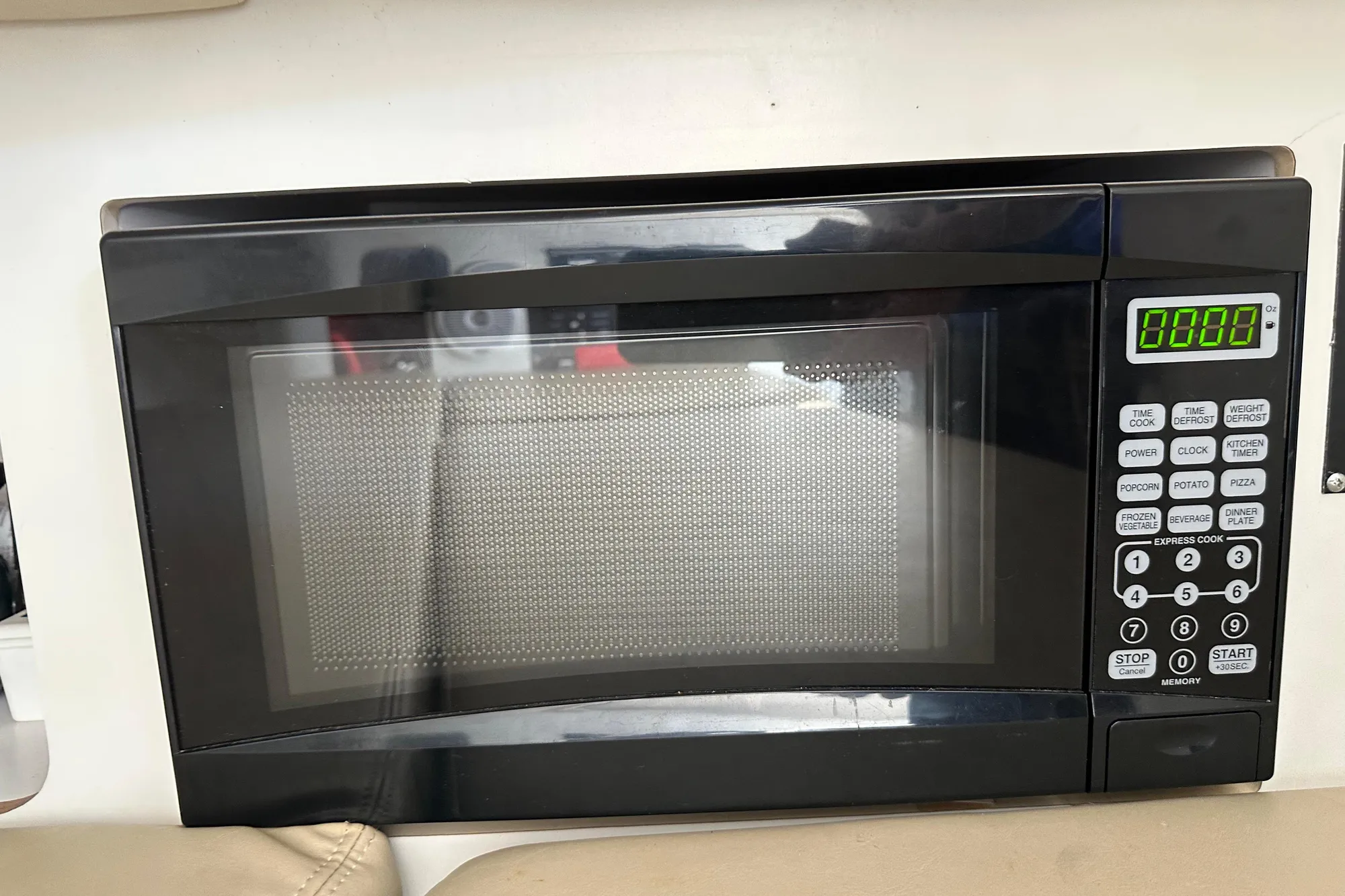 Microwave oven inside a 2001 Boston Whaler 28 Outrage boat, featuring digital controls.