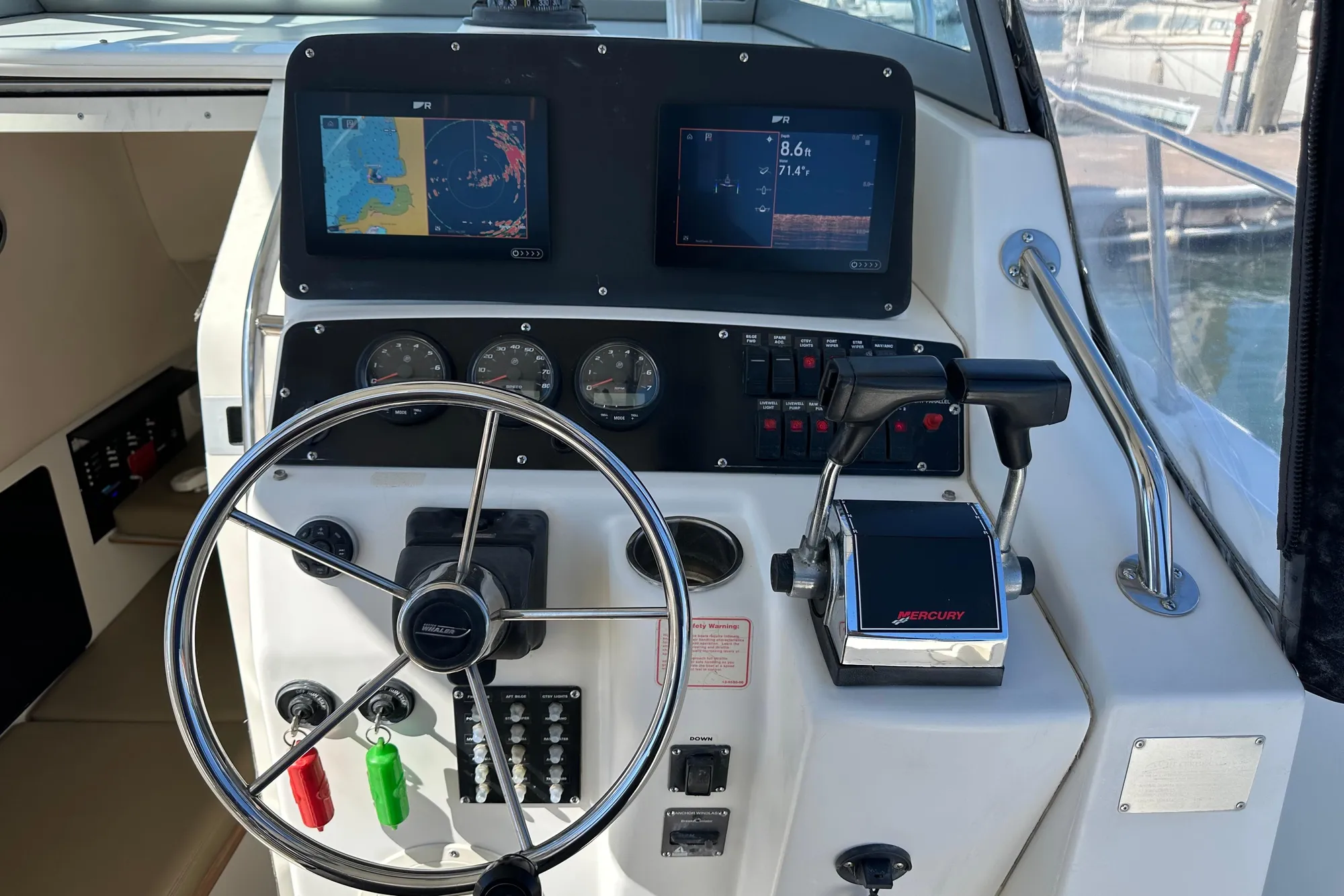Control panel of a 2001 Boston Whaler 28 Outrage boat with navigation screens.